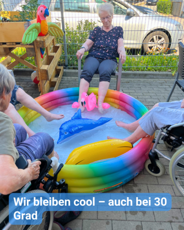 Vier ältere Personen kühlen ihre Füße in einem bunten Planschbecken. Text: 'Wir bleiben cool – auch bei 30 Grad'.