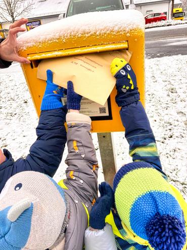 Auf diesem Bild sieht man, wie die Kinder ihre Wunschzettel in den Briefkasten werfen.t.