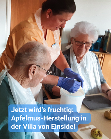 Eine Betreuerin schält mit einer Seniorin und einem Senior Äpfel am Küchentisch. Bildbeschriftung: „Jetzt wird’s fruchtig: Apfelmus-Herstellung in der Villa von Einsidel“