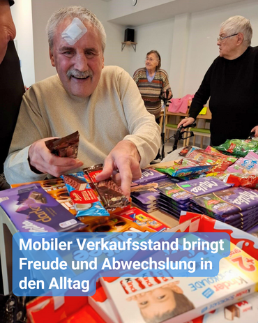 In einer Seniorenresidenz sind ältere Menschen beim einkaufen. Einer von Ihnen strahlt bei dem Anblick von Süßigkeiten, und er sucht sich gerade Schokolade heraus. Bildbeschriftung: “Mobiler Verkaufsstand bringt Freude und Abwechslung in den Alltag”