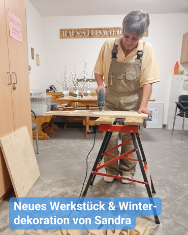 Betreuungskraft lebt ihre kreative Ader aus. Sie steht an der Werkbank und bearbeitet Holz. Bildbeschriftung: “Neues Werkstück & Winterdekoration von Sandra”