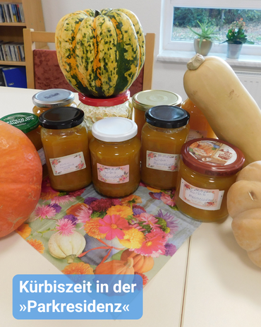 Auf dem Tisch sind verschiedene Kürbissorten und Kürbis eingekocht im Glas. Bildbeschriftung: Kürbiszeit in der Parkresidenz