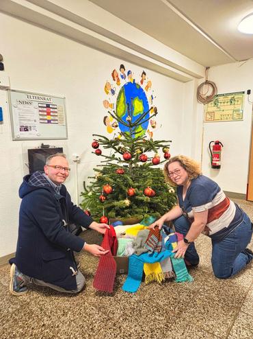 Auf diesem Bild sieht man, wie die Schals übergeben werden.