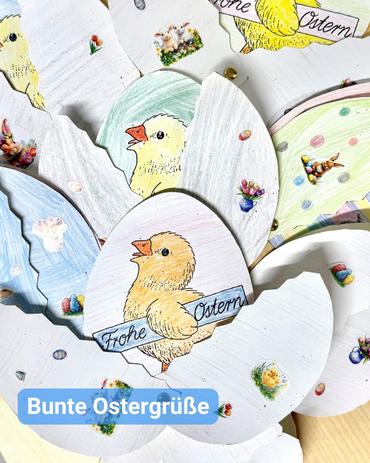 Nahaufnahme einer Vielzahl handgefertigter Osterkarten und Dekorationen.  Die Karten sind eiförmig gestaltet, wobei einige ganz und andere aufgebrochen sind. Sie sind mit Zeichnungen von Küken, Blumen und osterspezifischen Motiven geschmückt. Die Küken sind überwiegend gelb und in verschiedenen Posen abgebildet. Der Stil ist kindlich und einfach, wobei Buntstifte oder Wachsmalkreiden verwendet wurden. Viele Karten tragen die Worte „Frohe Ostern“ und „Bunte Ostergrüße“. Der Hintergrund zeigt eine Palette von Pastellfarben.  Die Karten sind übereinander geschichtet, was ein Gefühl von Tiefe und Fülle vermittelt. Der Gesamteindruck ist der einer fröhlichen und liebevoll gestalteten Osterbastelei.