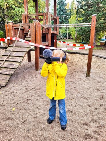 Auf dem Bild ist ein Kind mit einer Kamera zu sehen.