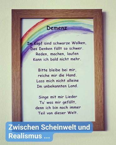 Nahaufnahme eines gerahmten Drucks.  Der Rahmen besteht aus hellbraunem Holz und ist relativ schlicht sowie unverziert.  Der Druck zeigt ein Gedicht in deutscher Sprache über Demenz, das von einem aquarellartigen Regenbogen an der Oberseite begleitet wird. Das Gedicht thematisiert die Herausforderungen der Krankheit und bittet um Nähe und Verständnis. Der Text ist in einer klaren, serifenlosen Schriftart sauber gedruckt.  Der Hintergrund bildet eine einfarbige, helle Wand.  Im Vordergrund ist eine Bildunterschrift zu sehen, mit weißer Schrift auf blauem Hintergrund: “Zwischen Scheinwelt und Realismus …”
